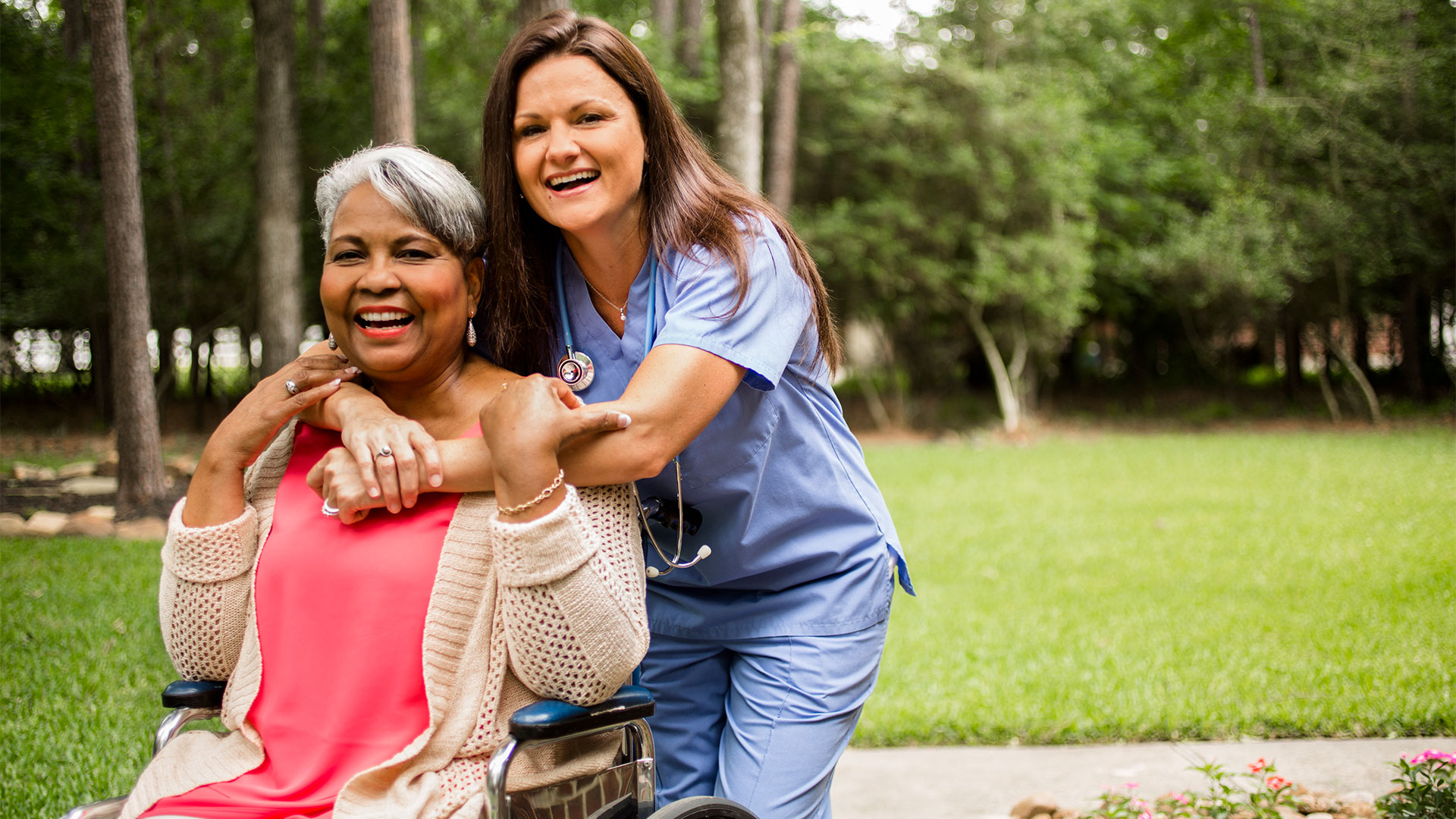 Image of nurse hugging patient in wheelchair